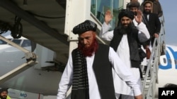 Abdul Karim (L) and Abdul Zahir (C), two former prisoners who had been held at the U.S. detention center in Guantanamo Bay before being transferred to Oman, are seen as they arrive at Kabul airport in Kabul, Afghanistan, Feb. 12, 2024. 