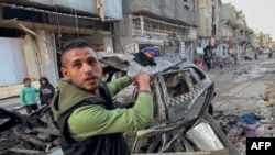 ชายคนนี้ชี้ไปที่รถยนต์ที่บุตรชาย 3 คนของผู้นำฮามาสอิสมาอิล ฮานิเยห์ ใช้ในการเดินทาง ก่อนถูกสังหารระหว่างการโจมตีทางอากาศของอิสราเอล ในกาซ่า ซิตี้ เมื่อ 10 เม.ย. 2024 (Photo by AFP)