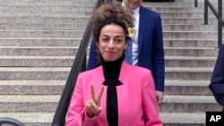 FILE - Iranian dissident and journalist Masih Alinejad flashes the victory sign following a court hearing in New York City, April 7, 2023.