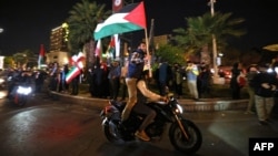 Demonstrators wave Iran's flag and Palestinian flags as they gather at Palestine Square in Tehran, Iran, on April 14, 2024, after Iran launched a drone and missile attack on Israel. 