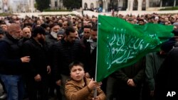 A young boy holds up a Hamas flag as people gather during a pro-Palestinian protest after Friday prayers outside Beyazit mosque in Istanbul, Nov. 24, 2023. 
