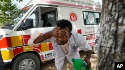 Jitendra Kumar, a paramedic who travels in ambulance, washes his face with water to cool himself off after dropping a patient at Lalitpur district hospital, in Banpur, in Indian state of Uttar Pradesh, June 17, 2023.