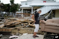 FILE - Tina Brotherton, 88, looks over the remains of her business, Tina's Dockside Inn, which was completely destroyed in Hurricane Idalia, as was Brotherton's nearby home, in Horseshoe Beach, Florida, Sept. 1, 2023.