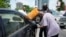 FILE - A man buys black market fuel in Lagos, Nigeria, May 30, 2023. Fuel prices soared in Nigeria last year after President Bola Tinubu ended subsidies that had kept prices low for many years.