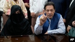 FILE - Pakistan's former Prime Minister Imran Khan, right, and his wife, Bushra Bibi, speak to the media at a court in Lahore, Pakistan, July 17, 2023. On Thursday, a U.S. official rejected the charge that he or his government played a role in fomenting Khan's ouster. 
