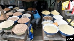 FILE - A vendor sits at his food stall waiting for buyers at a Lagos food market on July 25, 2023. Millions of people in Nigeria are struggling with economic problems analysts say were caused in part by government reforms introduced earlier this year. 
