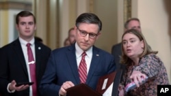 Speaker of the House Mike Johnson , center, stops to talk to reporters just after lawmakers pushed a $95 billion national security aid package for Ukraine, Israel and other U.S. allies closer to passage, at the Capitol in Washington, April 19, 2024. 