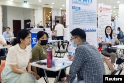 People attend a job fair in a mall in Beijing, China, June 30, 2023.