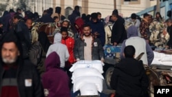 A man transports bags of flour distributed by a United Nations aid organization in Rafah in the southern Gaza Strip as fighting continues between Israel and the Palestinian Hamas group, Feb. 3, 2024.