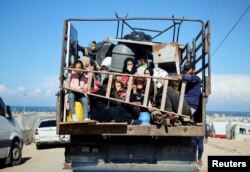 Displaced Palestinians fleeing Khan Younis due to the Israeli ground operation amid the ongoing conflict between Israel and the Palestinian Islamist group Hamas, sit on a vehicle as they move towards Rafah, in the southern Gaza Strip, Jan. 31, 2024.