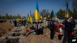 Undertakers lower the coffin of Ukrainian serviceman Andrii Vorobiov at the Kryvyi Rih cemetery in eastern Ukraine, April 24, 2023. 