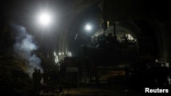 Lights illuminate the entrance of an under-construction road tunnel as rescue operations continue to free workers trapped inside following a collapse, in Uttarkashi, state of Uttarakhand, in northern India, Nov. 27, 2023.