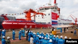 FILE - People attend the launch ceremony of China's first domestically built polar icebreaker, Xuelong 2, or Snow Dragon 2, at a shipyard in Shanghai, Sept. 10, 2018. 