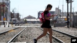 Heatwaves come up from the ground as a pedestrian walks past as temperatures reach 111-degrees, July 5, 2023, in Phoenix, Arizona.