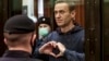 FILE - Pemimpin oposisi Rusia Alexey Navalny menunjukkan simbol hati dengan jari-jari tangannya, saat berdiri di dalam kurungan selama sidang di Pengadilan Kota Moskow, Rusia, 2 Februari 2021. Navalny meninggal dunia di penjara, pada usia 47 tahun. (Pengadilan Kota Moskow via AP)