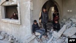 দক্ষিণ গাজার খান ইউনিসে ইসরাইলি বিমান হামলায় আল-ফাকায়ি পরিবারের বাড়ির ধ্বংসাবশেষ দেখছে ফিলিস্তিনিরা । (৫ মার্চ, ২০২৪) 