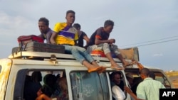 Peolpe displaced from Sudan's Jazira state arrive in packed vehicles to the entrance of the eastern city of Gedaref, Sudan, on June 10, 2024