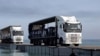 FILE - Trucks loaded with humanitarian aid from the United Arab Emirates and the United States Agency for International Development cross the Trident Pier before arriving on the beach on the Gaza Strip, May 17, 2024. 