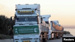 FILE - Aid trucks from Saudi Arabia line up at the border crossing from Turkey to Syria in the aftermath of an earthquake, Syria Feb. 11, 2023.