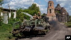 Ukrainian soldiers ride atop an armored vehicle in Ukraine's Sumy region, close to the country's border with Russia, Aug. 14, 2024.