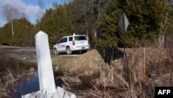 FILE - The marker of the U.S.-Canada border at Roxham Road on Feb. 26, 2017, in Champlain, New York. Many undocumented immigrants from India are entering the United States via Canada.