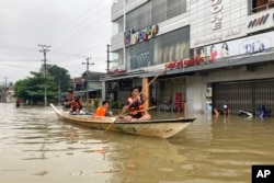 Volunteers use a boat on a flooded road in Bago, about 80 kilometers (50 miles) northeast of Yangon, Myanmar, Oct. 9, 2023.