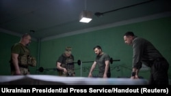 Ukraine's President Volodymyr Zelenskiy listens a report of Commander of the Ground Forces colonel general Oleksandr Syrskyi at a position near the front line in Donetsk region, June 26, 2023. 