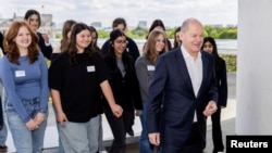 German Chancellor Olaf Scholz, leaves the terrace of the Chancellery with participants after a group picture during an event marking Girls' Day at the Chancellery in Berlin, April 23, 2024. 