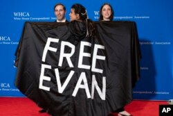 Wall Street Journal journalist Vivian Salama displays a cape with the name of her colleague WSJ correspondent Evan Gershkovich, who is detained in Russia, at the annual White House Correspondents' Association Dinner in Washington, April 29, 2023.