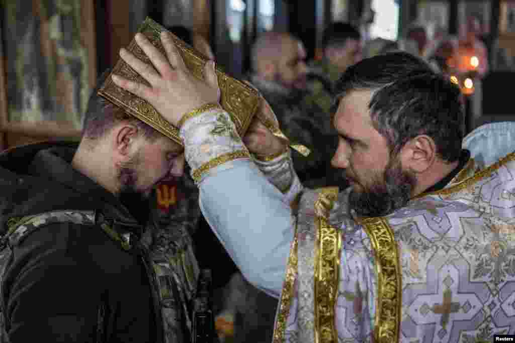  Ukrainian service members of the 4th Ivan Vyhovskyi Separate Tank Brigade attend a Christmas Eve service near the front line outside Kupiansk in Kharkiv region, Dec. 24, 2023.