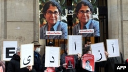 FILE - In this Jan. 13, 2022, photo, colleagues of academic Fariba Adelkhah hold placards in Paris in support following Iran's decision to send her back to prison after a period of house arrest. On Feb. 10, 2023, she was released from prison.