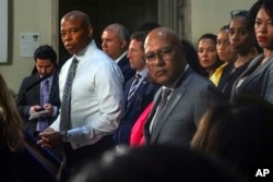 FILE - New York Mayor Eric Adams, left, with city officials at a press conference on Aug. 9, 2023, in New York, called for a national emergency declaration to ease the financial crisis the city faces as thousands of migrants arrive.