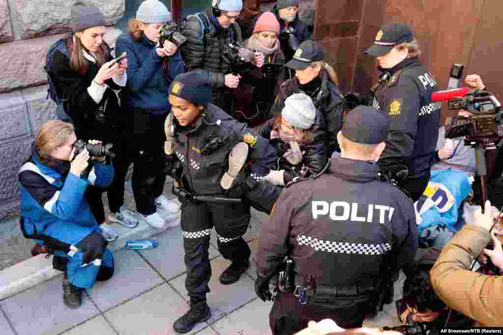 Norwegeian police carry away Greta Thunberg as activists demonstrate outside the Ministry of Finance entrance and several other ministries in Oslo, Norway, to protest wind turbines at Fosen that have not been demolished yet, although the Supreme Court has ruled they are illegal.