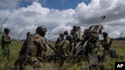 FILE - Ukrainian servicemen prepare to fire at Russian positions from a U.S.-supplied M777 howitzer in Kharkiv region, Ukraine, July 14, 2022. U.S. officials say the Pentagon will announce soon it is sending up to $500 million in military aid to Ukraine.