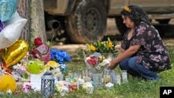 Maria Rodriguez places flowers outside the location of Friday's mass shooting in Cleveland, Texas, May 2, 2023. After a four-day manhunt, police have arrested a suspect.