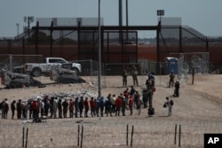 Migrants line up after being detained by U.S. authorities at the U.S.-Mexico border in Ciudad Juárez, Mexico, April 30, 2023.