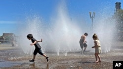 Children play in a fountain to cool off in Portland, Oregon, May 12, 2023. A heat wave this weekend could surpass daily records in the Pacific Northwest, a historically temperate region that has grappled with scorching summer temperatures in recent years.