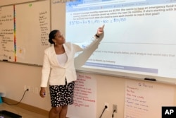 Tonica Tatum-Gormes leads her students through a math problem involving a money-saving strategy at Capital City Public Charter School in Washington on Sept. 12, 2023. (Jackie Valley/The Christian Science Monitor via AP)