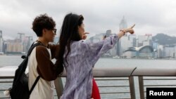 两名中国年轻人五一节前到香港游玩时在小红书上寻找旅游攻略。（2024年4月30日）