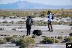 In this NASA photo, members of a recovery team from Lockheed Martin prepare to transport the asteroid sample, which touched down at the Department of Defense's Utah Test and Training Range on Sunday, Sept. 24, 2023. (Keegan Barber/NASA via AP)