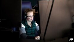 FILE - A 911 dispatch trainee works at a computer in Denver, Oct. 20, 2022. The city's STAR program uses clinicians and EMTs or paramedics to respond to nonviolent mental health crises, instead of police. 