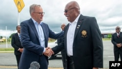 PM Fiji Sitiveni Rabuka (tengah kanan) berjabat tangan dengan PM Australia Anthony Albanese setibanya di Nadi, 15 Maret 2023. (LEON LORD / AFP)