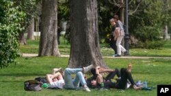 FILE - People relax in the Retiro park in Madrid, Spain, March 20, 2024. Earth just had its warmest March ever recorded, according to the European Union climate agency Copernicus. (AP Photo/Paul White, File)