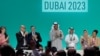 Le président de la COP28, Sultan Ahmed Al Jaber (centre), applaudit parmi d'autres responsables à la COP28 à Dubaï le 13 décembre 2023.