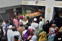 People carry the body of a victim of the train derailment for a funeral prayer, in Hyderabad, Pakistan, Aug. 7, 2023.