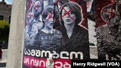 A Georgian government propaganda poster shows Eka Gigauri of Transparency International, center of photo, alongside other civil society leaders, in Tbilisi, Georgia, June 7, 2024. The caption reads: “Our homeland can never be sold!" (Henry Ridgwell/VOA)