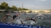 Sejumlah atlet triathlon terjun ke Sungai Seine dengan Menara Eiffel sebagai latar belakang dalam acara Tes Olimpiade Triathlon Dunia 2023 putra di Paris, 18 Agustus 2023. (Foto: AFP)