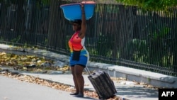 A woman leavevs an area that was set fire to by armed gangs in Port-au-Prince, Haiti, on March 25, 2024.