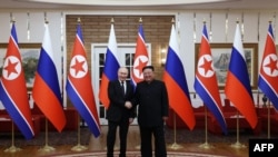 In this pool photograph distributed by the Russian state agency Sputnik, Russia's President Vladimir Putin shakes hands with North Korea's leader Kim Jong Un during a meeting in Pyongyang on June 19, 2024. (Gavriil Grigorov/ Pool / AFP) 