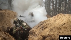 FILE - Ukrainian servicemen take part in radiation, chemical and biological hazard drills, amid Russia's invasion of Ukraine, near Kharkiv, Ukraine Feb. 29, 2024.